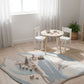 Children's play area with a round table and chairs on a patterned rug.