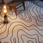 Rug with wavy pattern on a floor next to a lamp