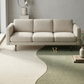 Beige sofa in a modern living room with a decorative rug and minimal decor.