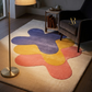 Colorful abstract rug in a living room with a chair and lamp.