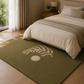 An olive green area rug with a cream palm leaf and circle pattern, styled under a bed in a warm, modern bedroom.