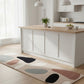 Modern kitchen with a wooden island and a colorful rug on the floor.