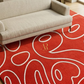 Red patterned rug with white lines on a beige sofa