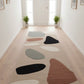 Colorful abstract rug on a wooden floor with large windows in the background