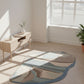 Modern room with a geometric-patterned rug on wooden flooring, light-colored walls, and a window.