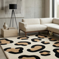 Modern living room with a beige sectional sofa, patterned rug, and decorative lamp.