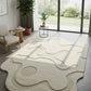 Modern living room with a wavy patterned rug, chairs, and plants.
