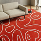 Red patterned rug with white lines in a living room setting