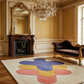 Luxurious room with a chandelier, mirror, fireplace, and colorful rug.