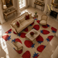 A styled living room scene showing a cream-colored area rug with a bold red and blue strawberry pattern, surrounded by elegant beige furniture and columns.