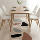 Dining room with a wooden table and chairs, featuring a colorful abstract rug on the floor.