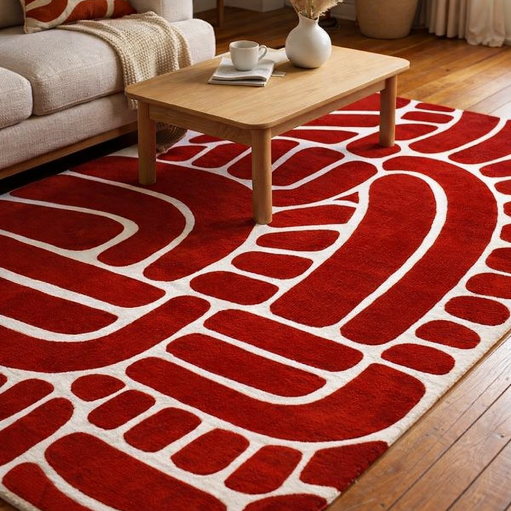 Red patterned rug on a wooden floor with a coffee table and sofa in the background.