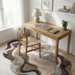 Wooden desk with chair in a room with a rug and window