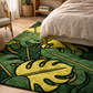 Green and yellow leaf-patterned rug in a bedroom setting with a bed and chair.