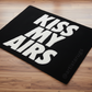 Black doormat with 'KISS MY AIRS' text on a wooden floor