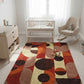 Nursery room with a colorful geometric rug, white crib, and rocking chair.