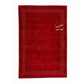 A red rectangular rug with a decorative border of small white dots and a gold monogram in the upper right corner, shown flat against a white background.
