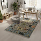 Living room with a colorful patterned rug, wooden furniture, and plants.