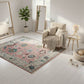 Living room with a floral rug, beige armchair, and decorative elements.