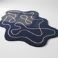 Navy blue mat with pink wavy lines on a white background