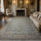 Luxurious living room with a large patterned rug, sofa, and fireplace.