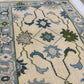 Close-up of a patterned rug with floral designs in blue, green, and beige.