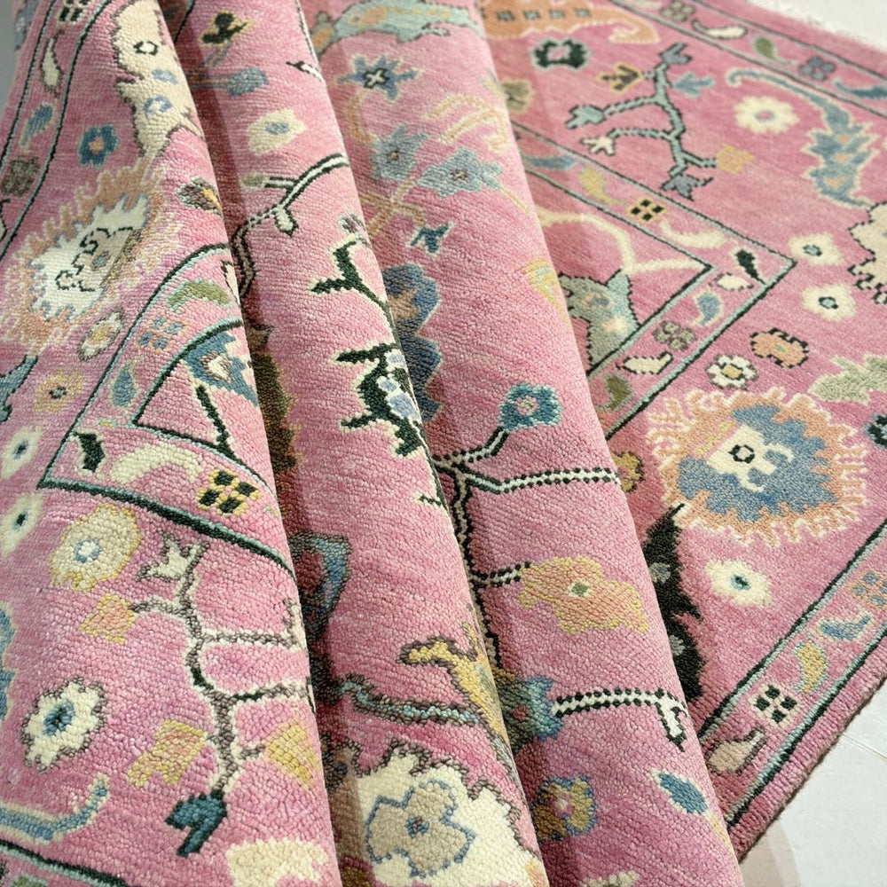 Close-up of a pink patterned rug with floral designs.