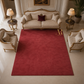 Luxurious living room with a red rug, beige sofa, and armchairs.