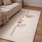 Beige rug with abstract line art of a face in a living room setting