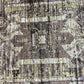 Close-up of a textured fabric with a geometric pattern in brown, beige, and black.