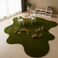 Children's playroom with a green rug, toys, and a small table.