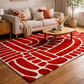 Living room with a red and white patterned rug, beige sofa, and wooden coffee table.