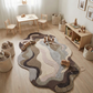 Children's playroom with a wavy patterned rug, wooden furniture, and toys.
