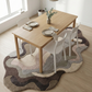 Dining table set with chairs on a patterned rug in a bright room.