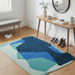 Blue and green abstract rug on a wooden floor with a wooden table and bench in the background.