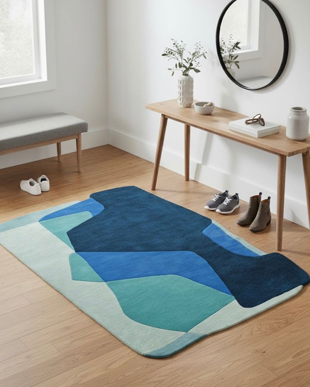 Blue and green abstract rug on a wooden floor with a wooden table and bench in the background.