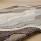 Textured area rug with wavy pattern on a wooden floor