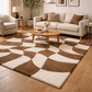 Living room with a patterned brown and beige rug, white sofa, and wooden coffee table.