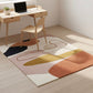 Modern office setup with a geometric patterned rug, desk, and chair.