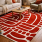 Living room with a red and white patterned rug, beige sofa, and wooden coffee table.