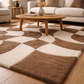 Brown and beige checkered rug in a living room setting with a wooden coffee table.