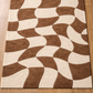Brown and beige patterned rug on a wooden floor