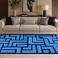 A modern living room scene featuring a prominent blue and navy geometric patterned area rug on a light wood floor in front of a beige fabric sofa with decorative pillows.