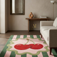Living room with a cherry-themed rug, sofa, and decorative items.