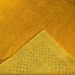 A close-up of a textured mustard yellow fabric with a triangular section showing a pattern of small black embroidered stars, on a matching yellow background.