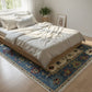 Bedroom with a bed covered in white bedding on a decorative rug.