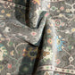 Close-up of patterned fabric with intricate designs in various colors.