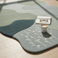 Decorative rug with a cup of coffee and glasses on a light wooden floor