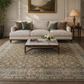 Living room with a beige sofa, coffee table, and decorative rug.