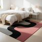 Modern bedroom with a wavy patterned rug in pink, black, and gray.